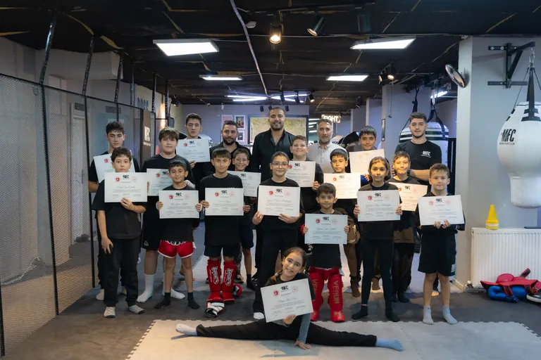 Mengeş Fight Club çocuk grubu kuşak sınavı sonrası antrenörleriyle